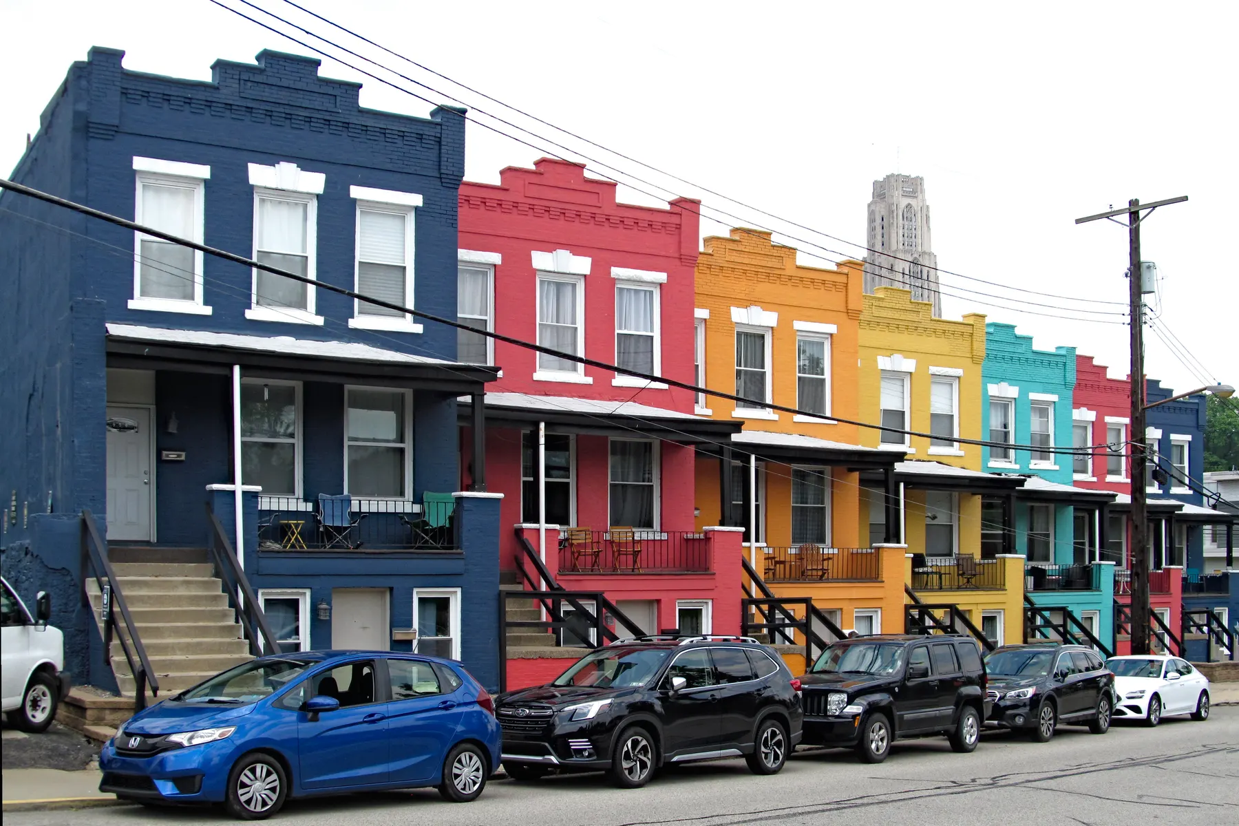 Row of houses painted in different colors along a street